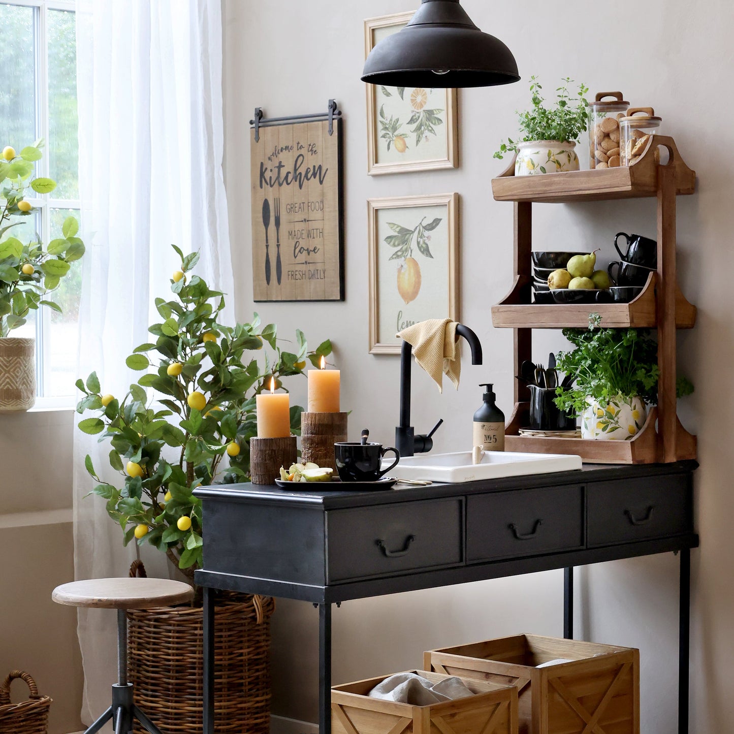 Cozy kitchen decor with a lemon blossom ceramic jug, plants, and candles on a stylish black console table.