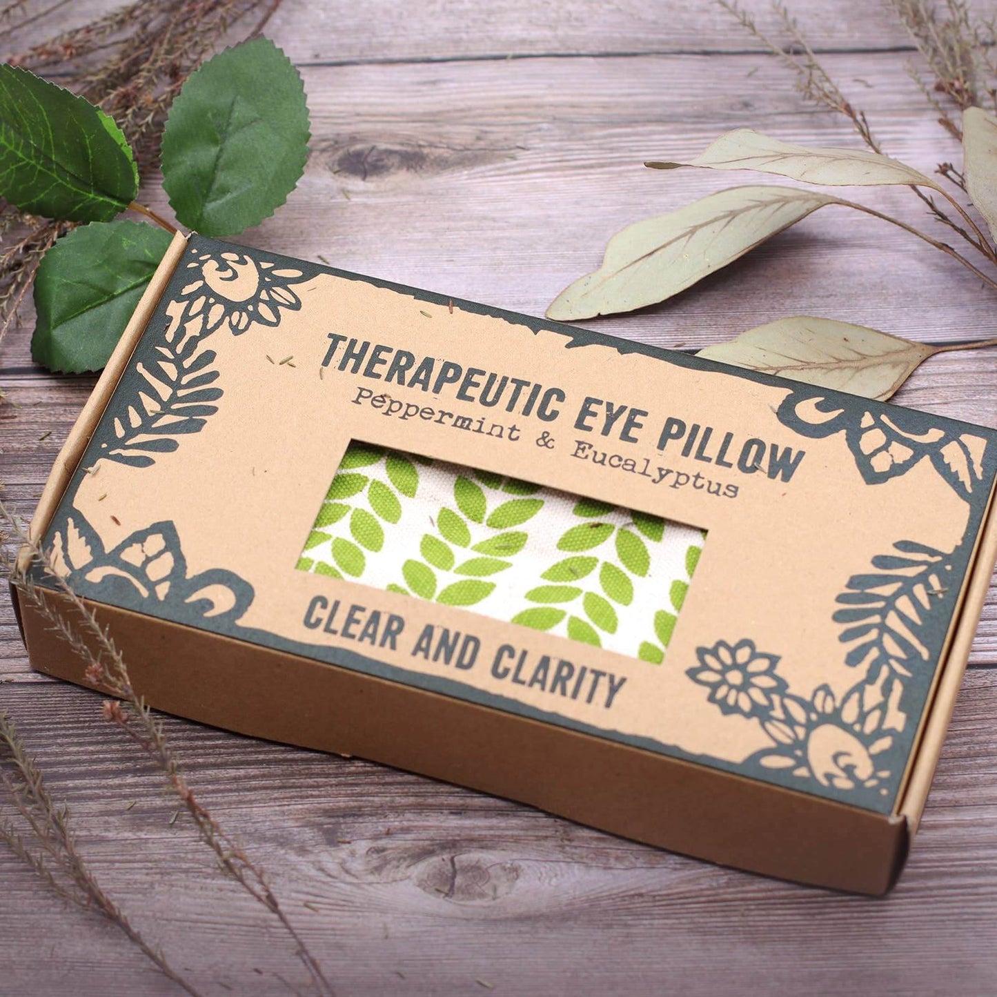 brown box with window showing clear and clarity eye pillow on wooden background