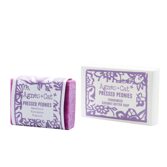 A bar of coconut butter soap with pressed peonies embossed on the packaging, indicating the scent and brand.