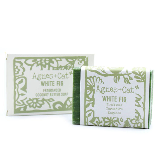 Bars of Agnes and Cat White Fig Coconut Butter Soap, embossed on the packaging with a floral design and the scent marked as White Fig. The packaging is predominantly white and green with 'AGNES + CAT' branding.