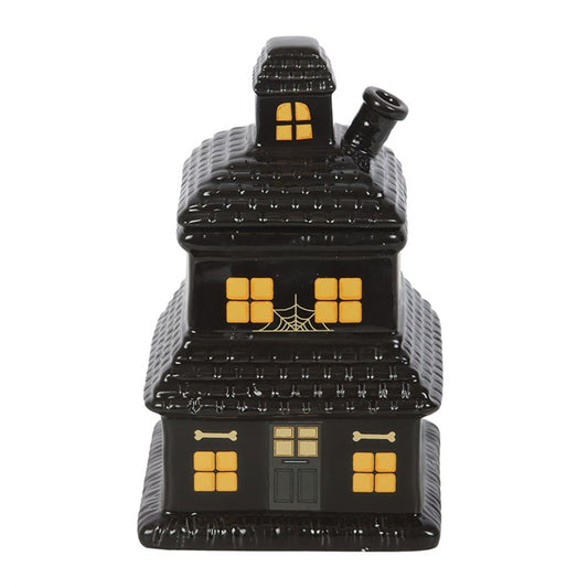 Black haunted house-shaped container with yellow windows on a white background