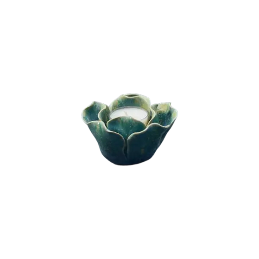 Graduated Blue coloured ceramic t light holder in the shape of a flower on a white background showing candle insert