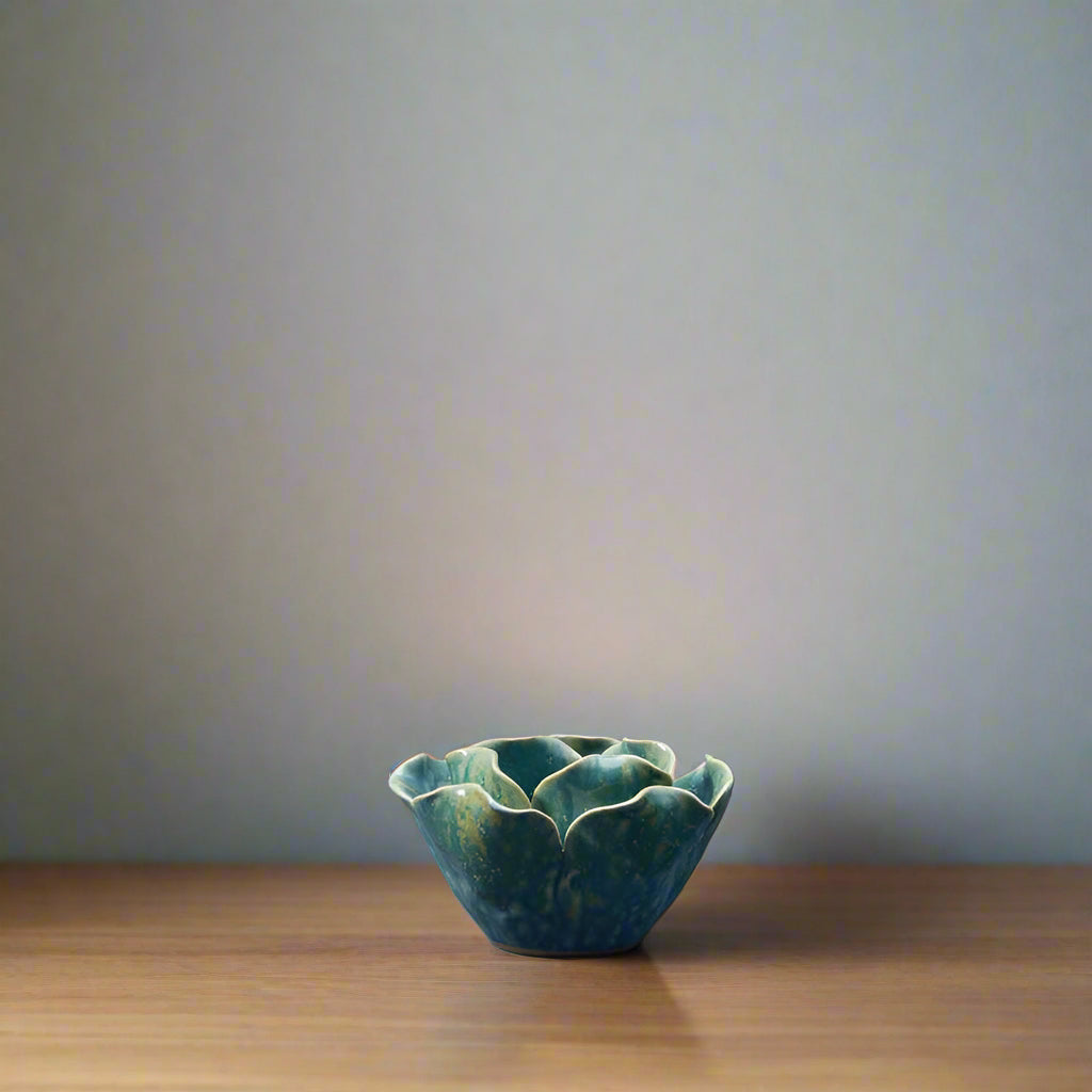 Graduated Blue coloured ceramic t light holder in the shape of a flower.