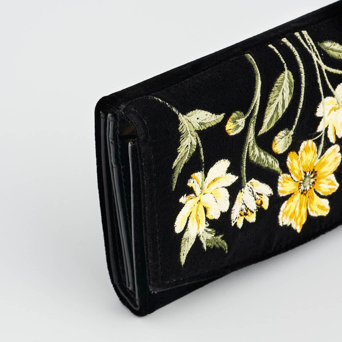 Black wallet with yellow floral embroidery on a white background