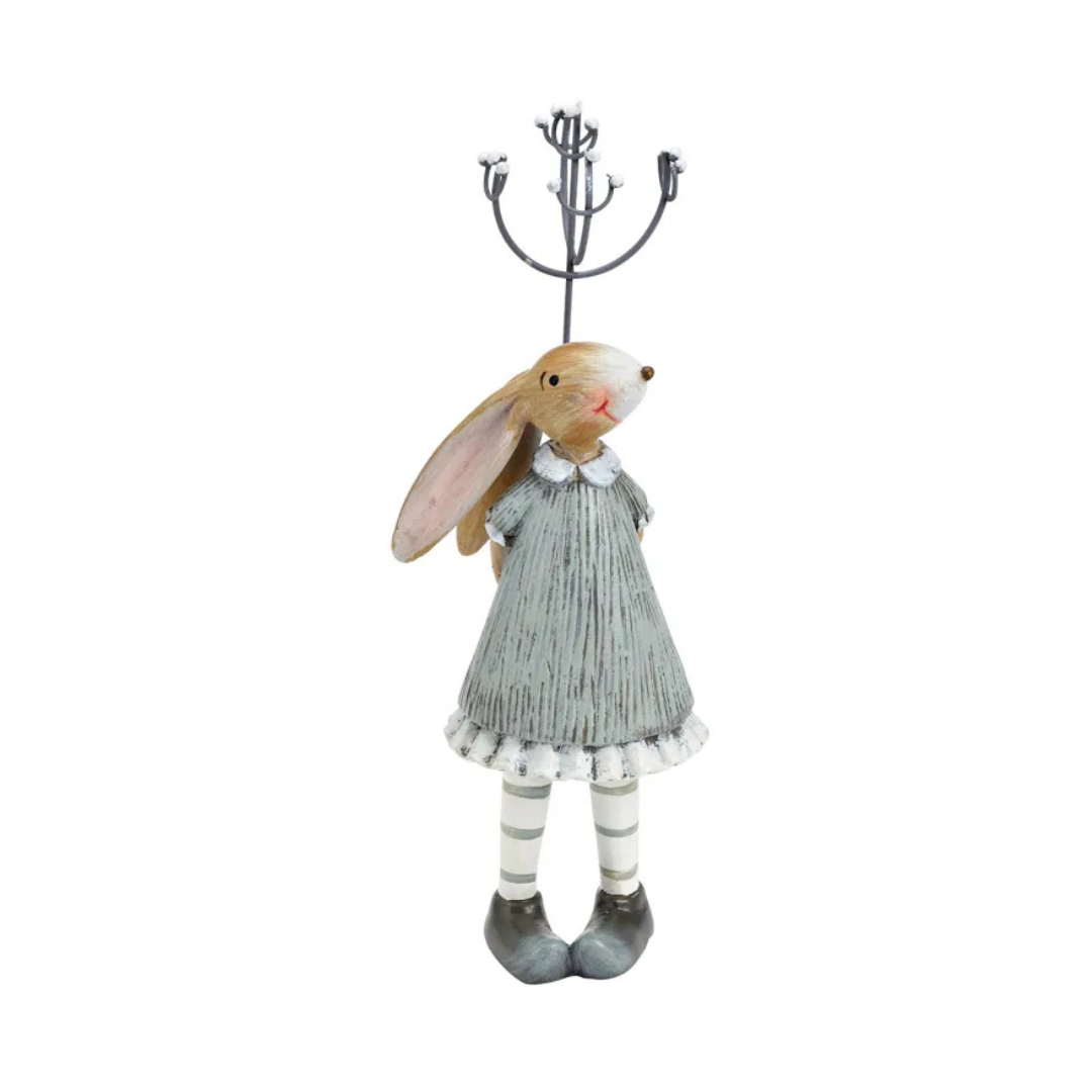 Decorative rabbit figurine in a dress holding a candle holder on a white background