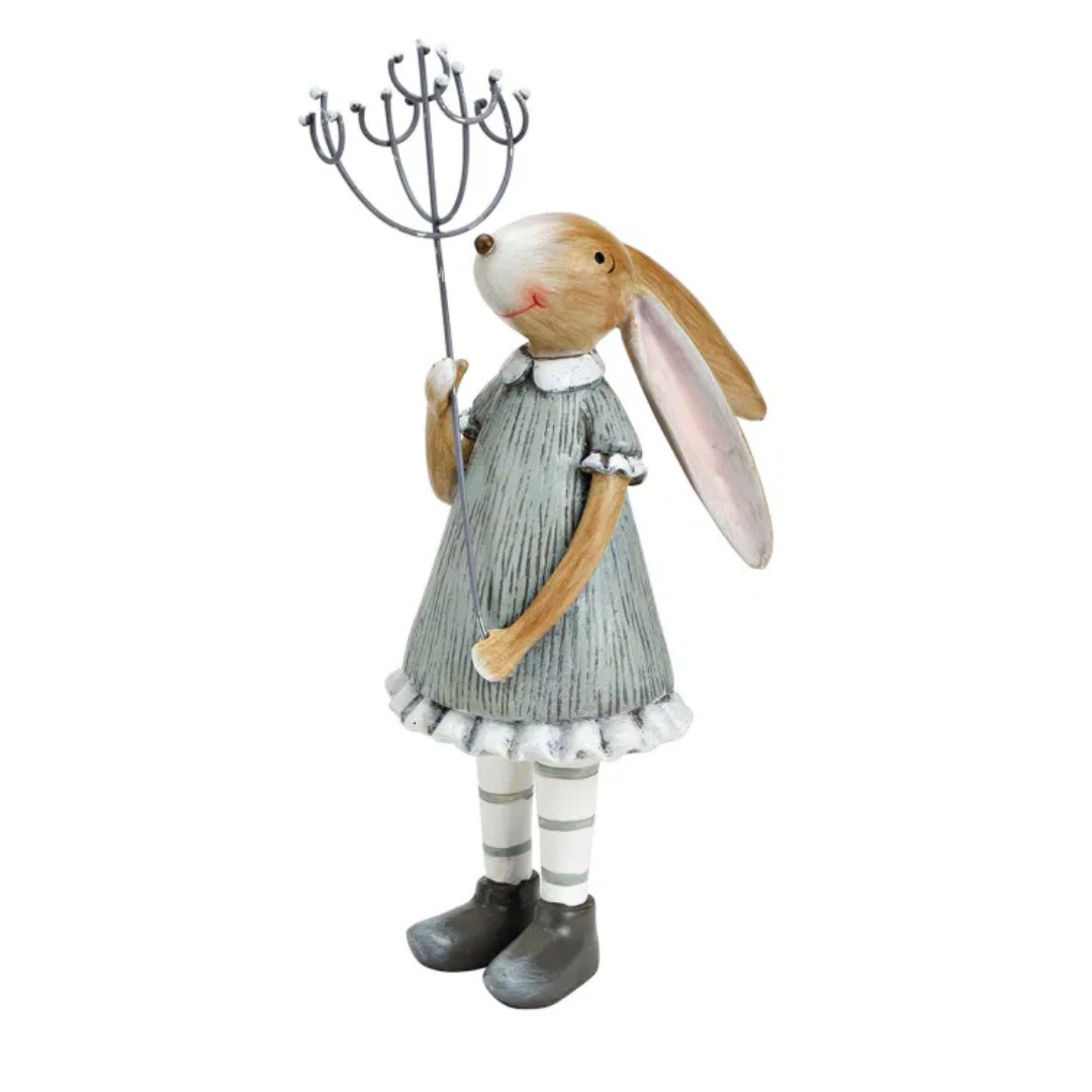 Decorative rabbit figure in a dress holding a whisk on a white background
