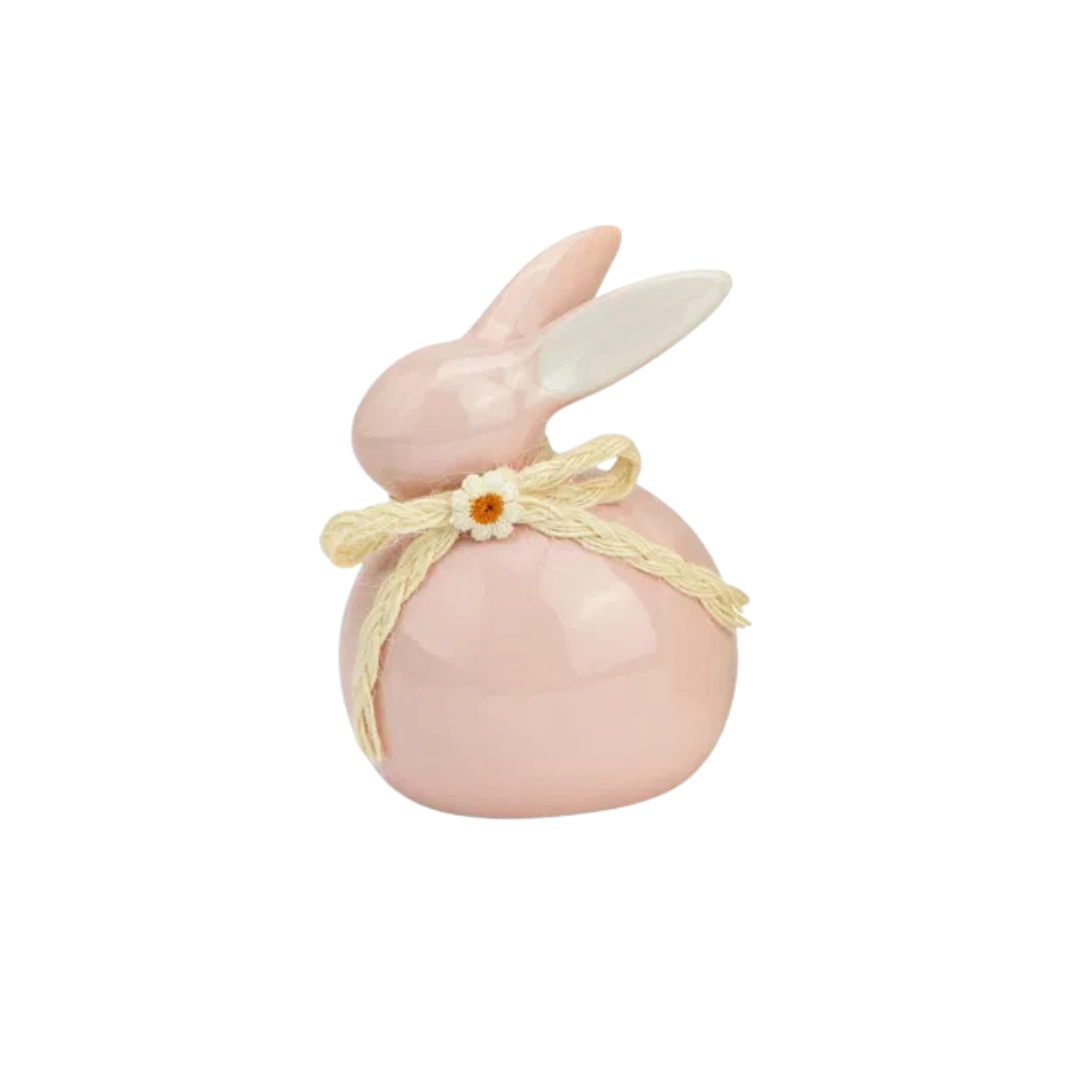 Pink rabbit-shaped object with a bow on a white background