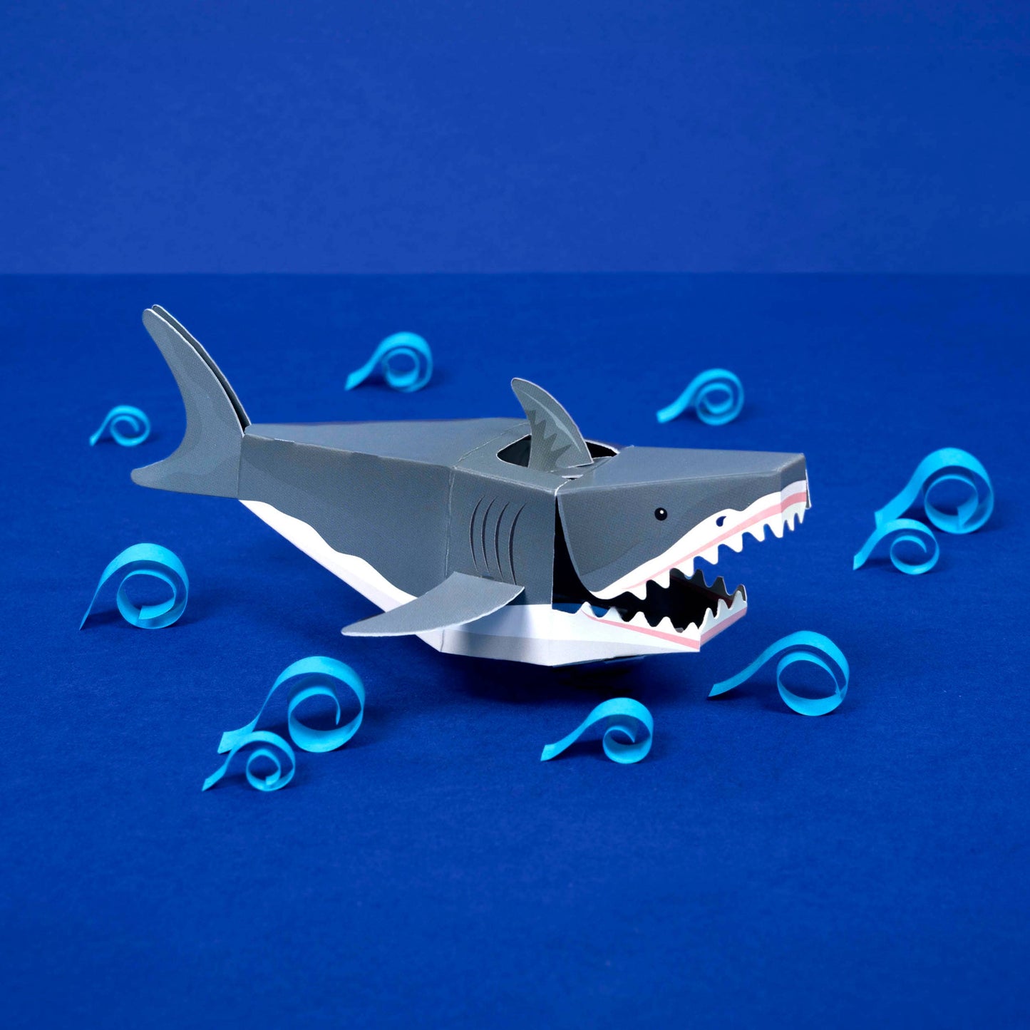 Toy shark with swirling blue patterns on a blue background