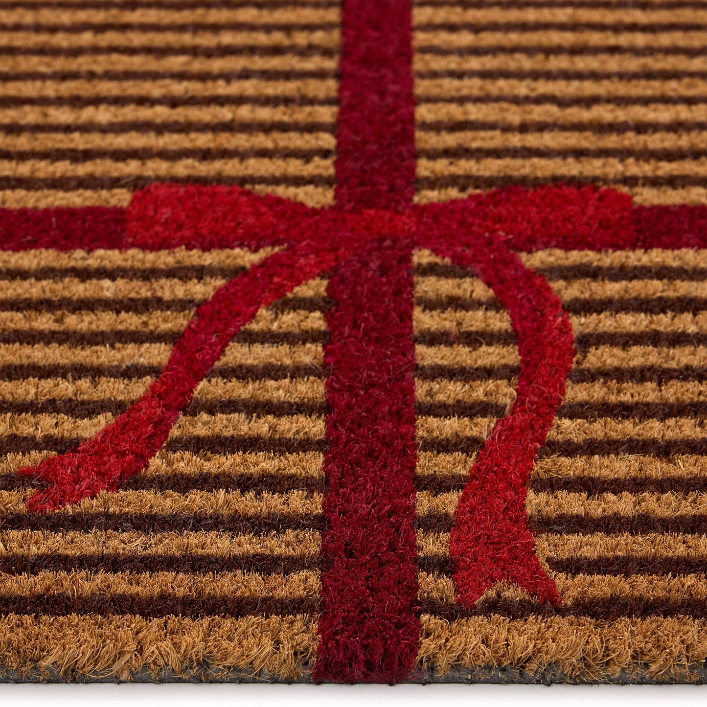 Doormat with red 'A' logo on a brown and red striped background