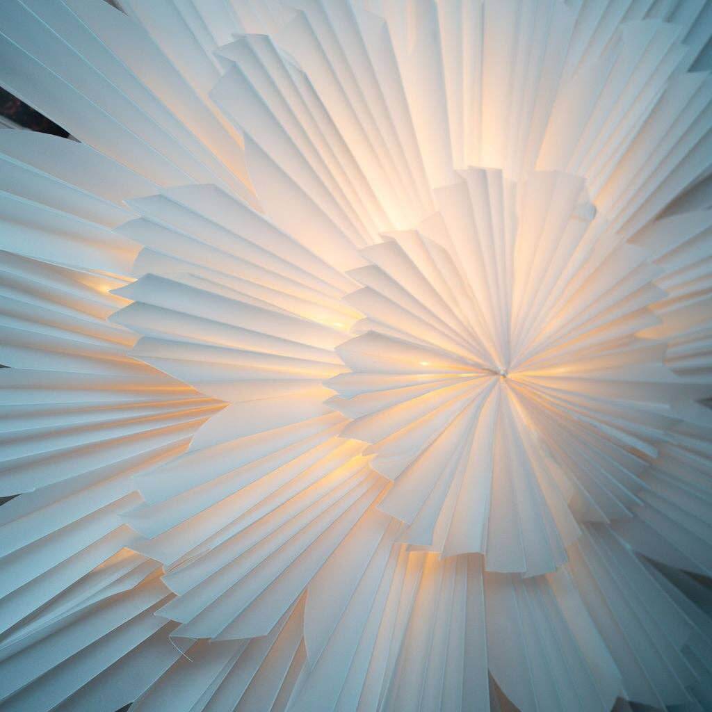 Close up of large paper flower decoration lit up inside with fairy lights