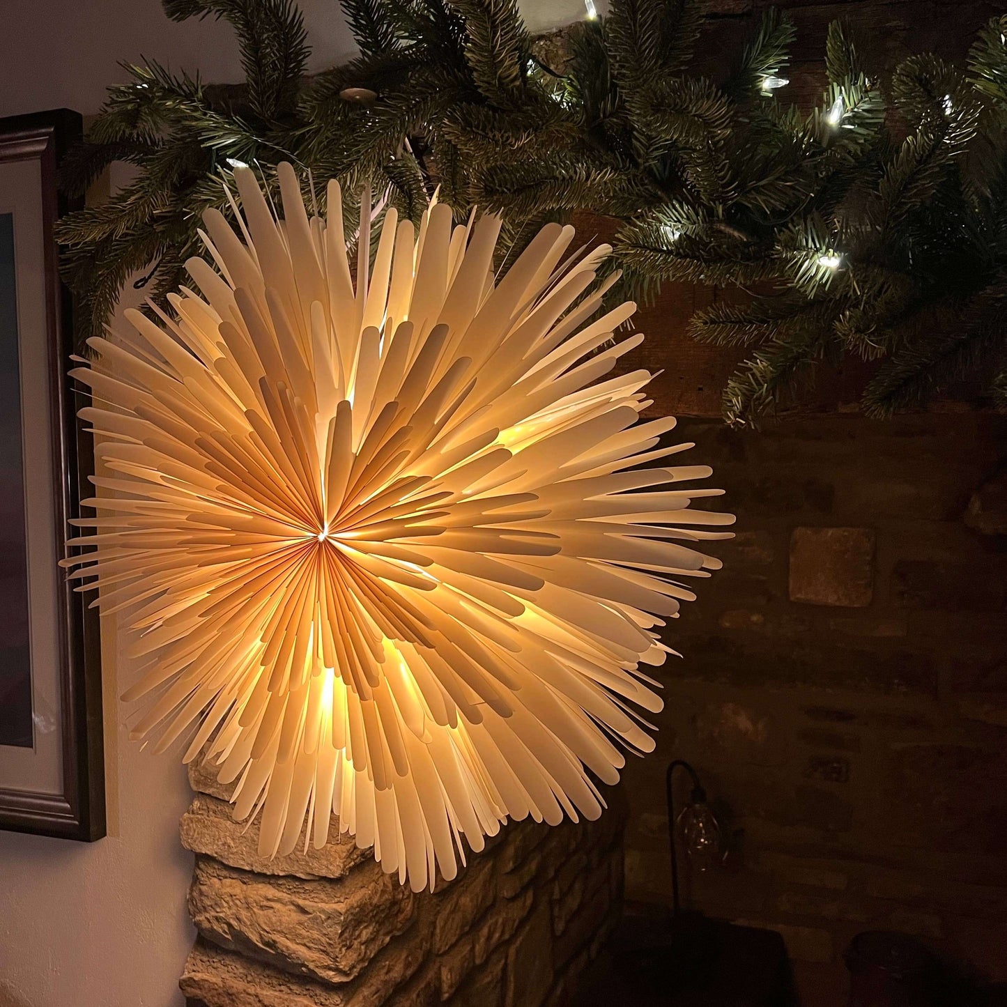 Close up of starburst decoration with Christmas garland on fireplace