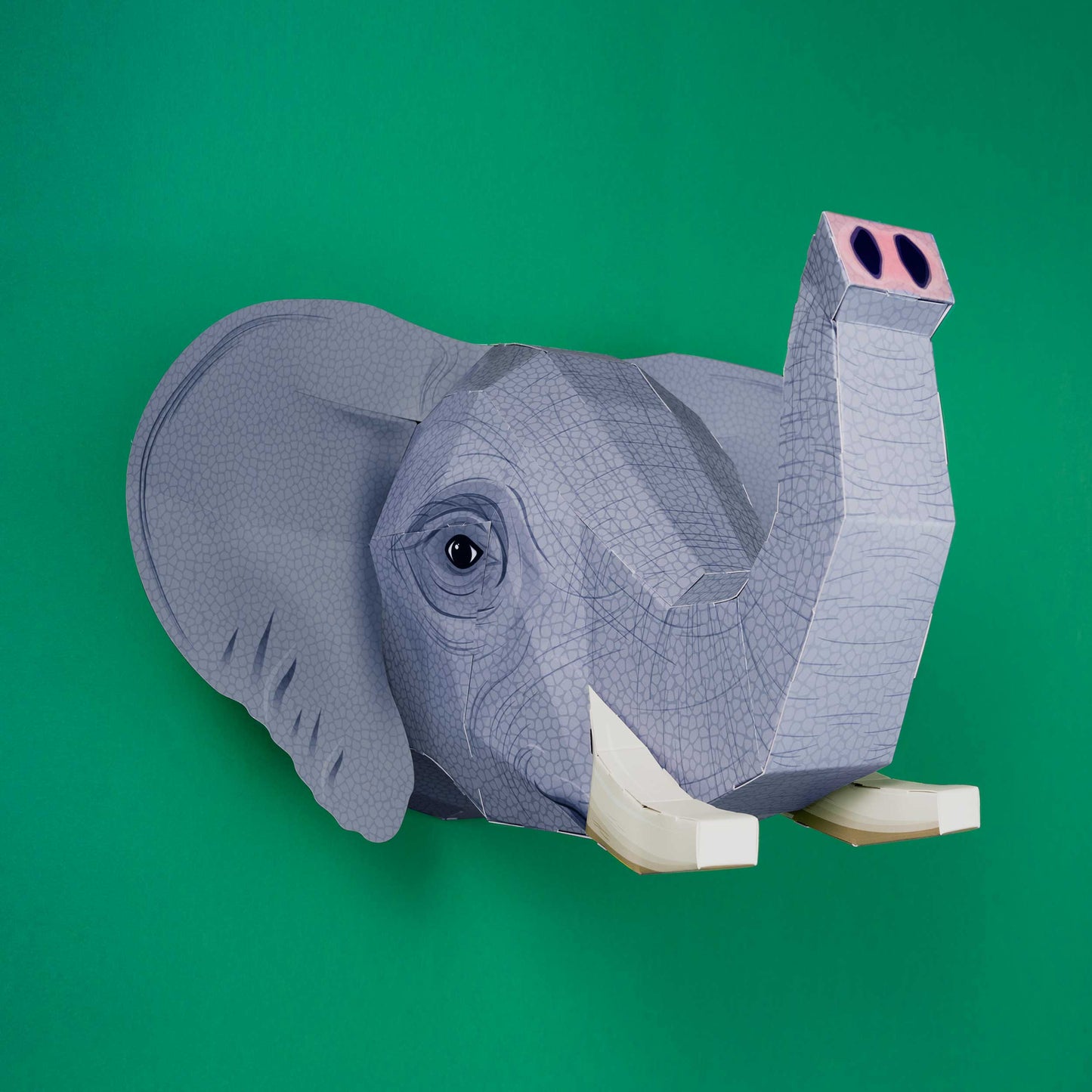 Gray elephant head sculpture on a green background