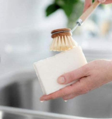 Lemon scented Eco Dish Soap Bar in ladies hand as she scrubs with the dish cleaning brush