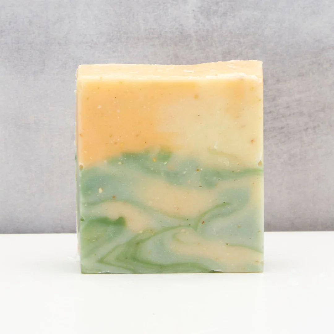 Marbled green and beige soap bar on a gray background