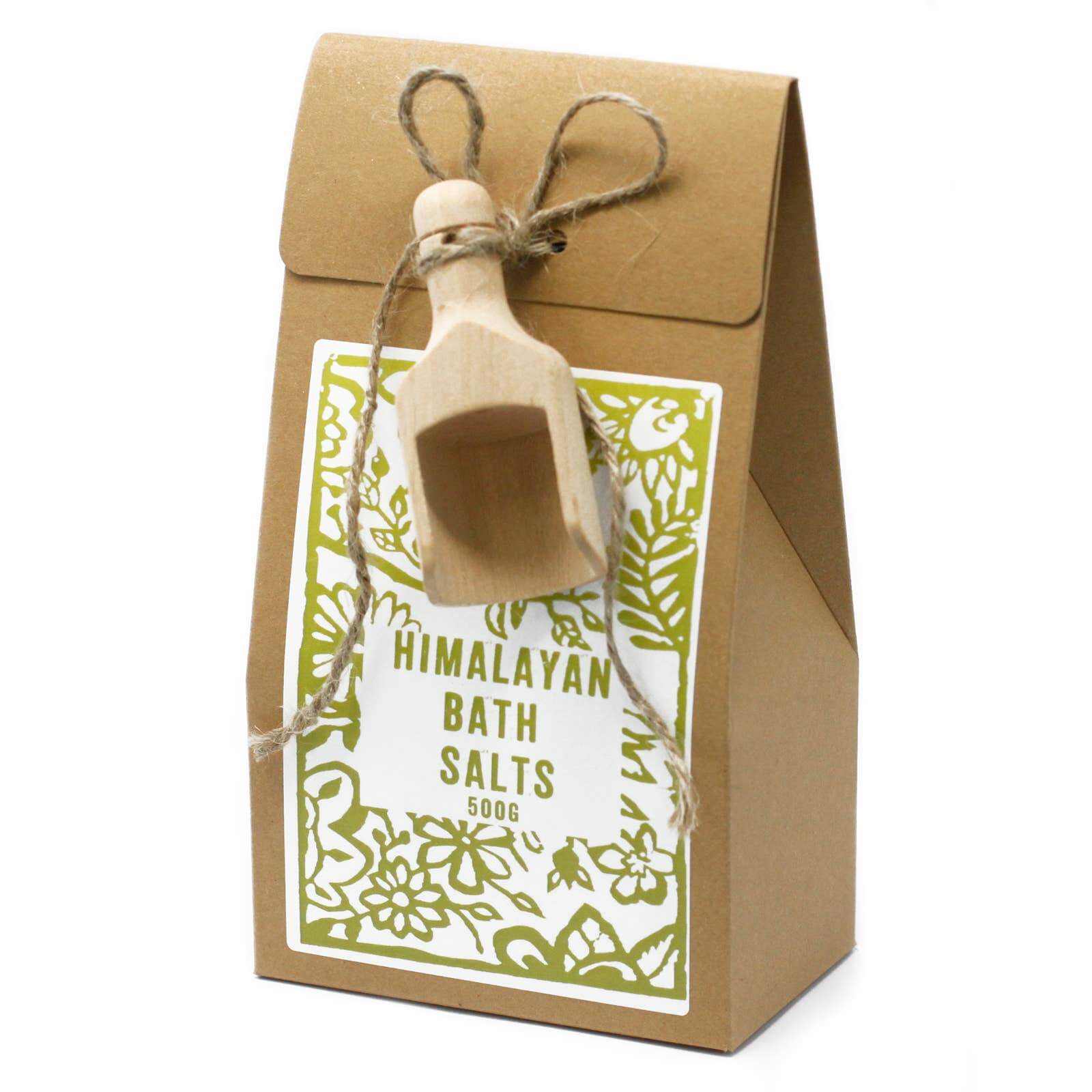 A package of Himalayan bath salts with a wooden scoop attached to the top, presented in a kraft paper bag with a green floral design and the brand name 'agnes + cat'.