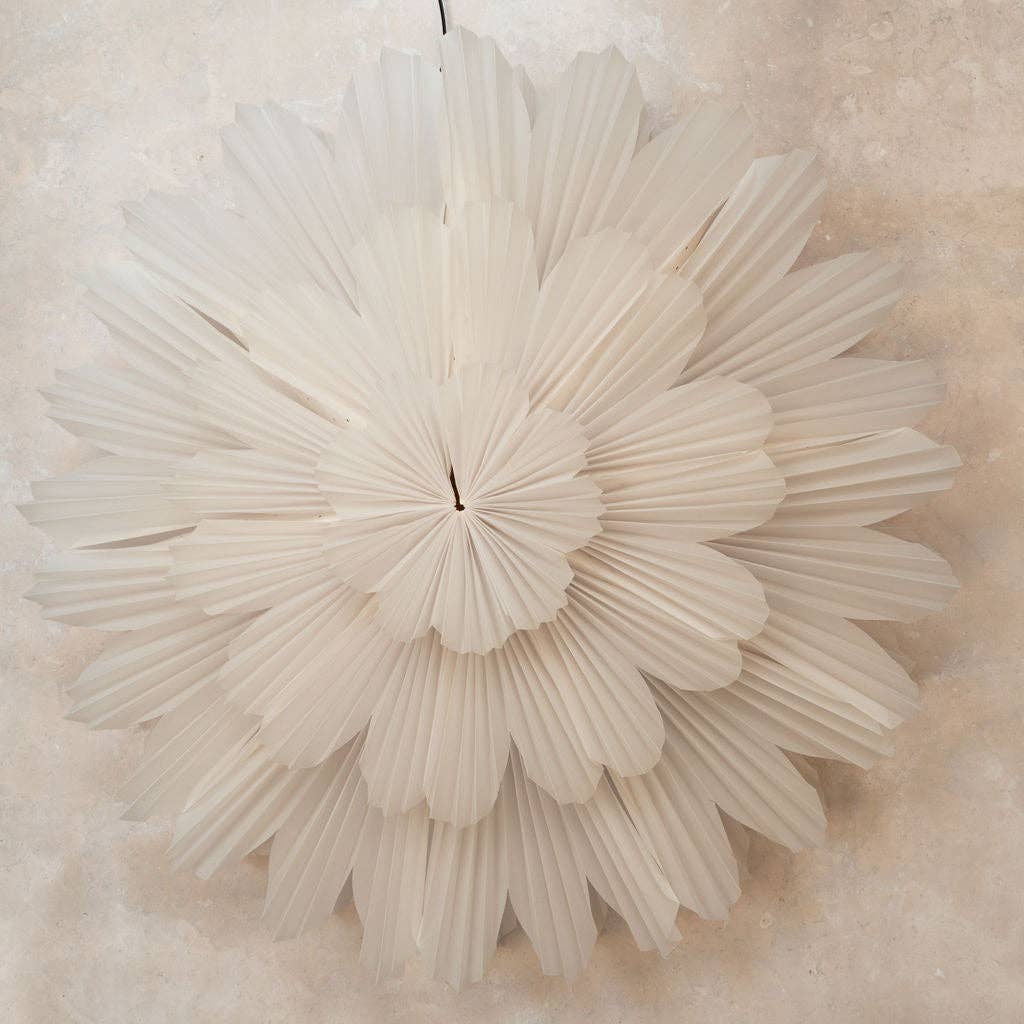 A large white paper wall hanging decoration with a flower-like design, intended to be used as a decorative piece on walls.
