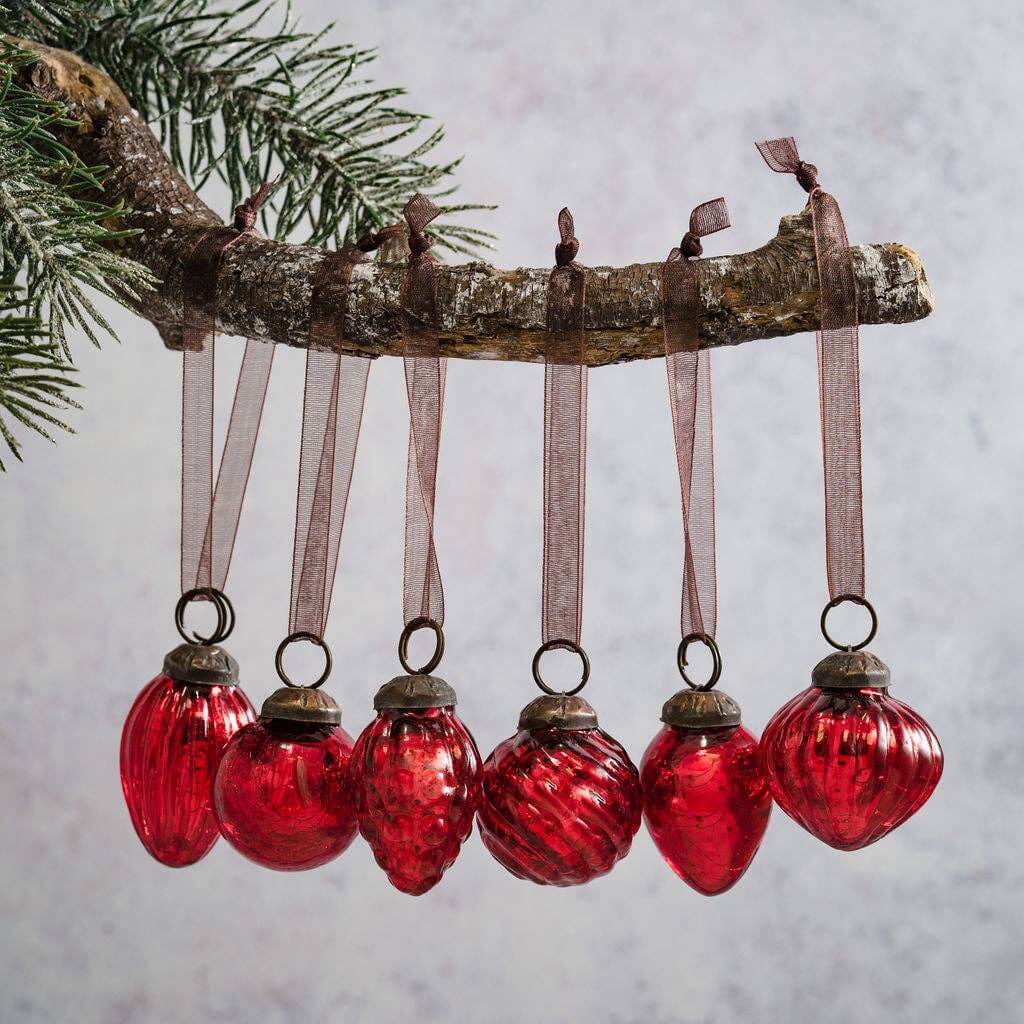 A set of 6 small red crackle glass baubles with ornate caps and organza ties, hanging from a wooden branch.