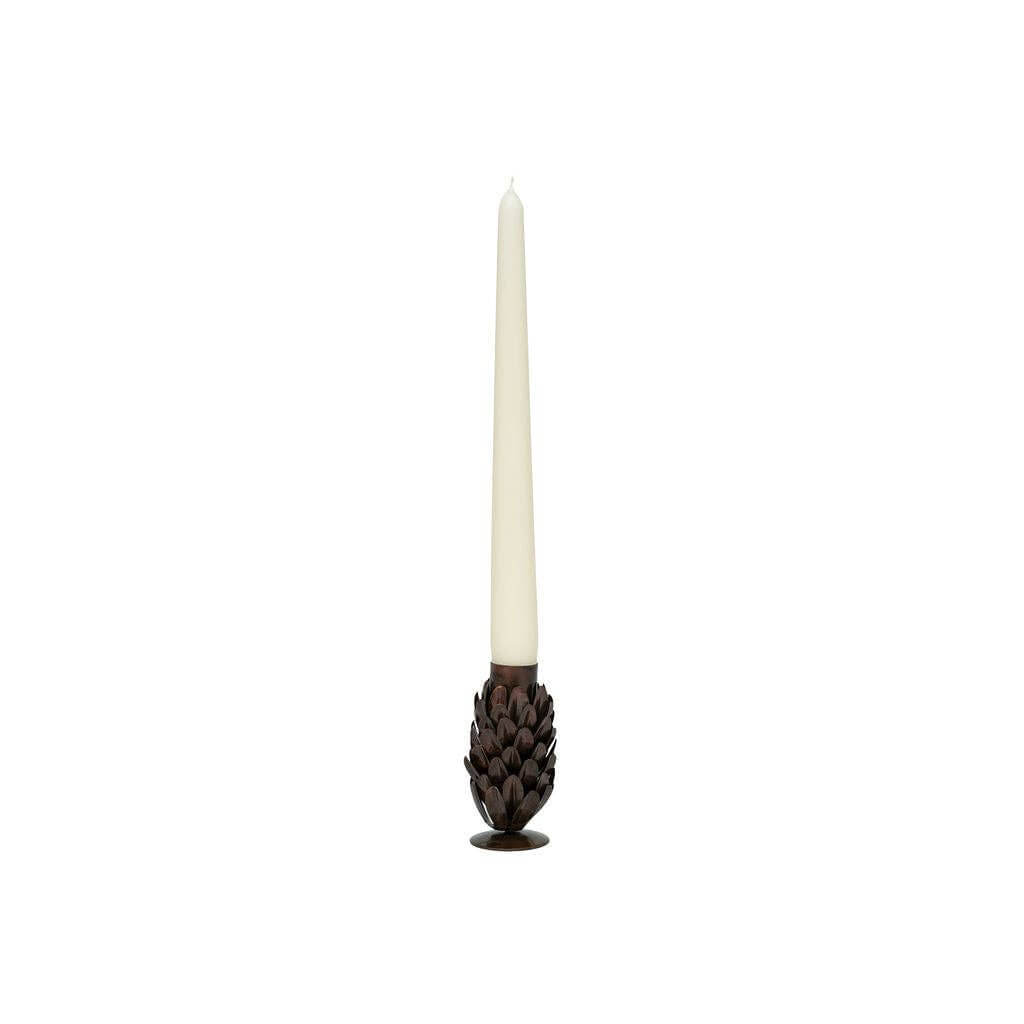Rustic metal pine cone look candle holder on white background with taper candle