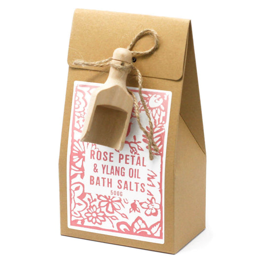 A package of 'Rose Petal & Ylang Oil Bath Salts' with a wooden scoop and a floral pattern on the packaging.