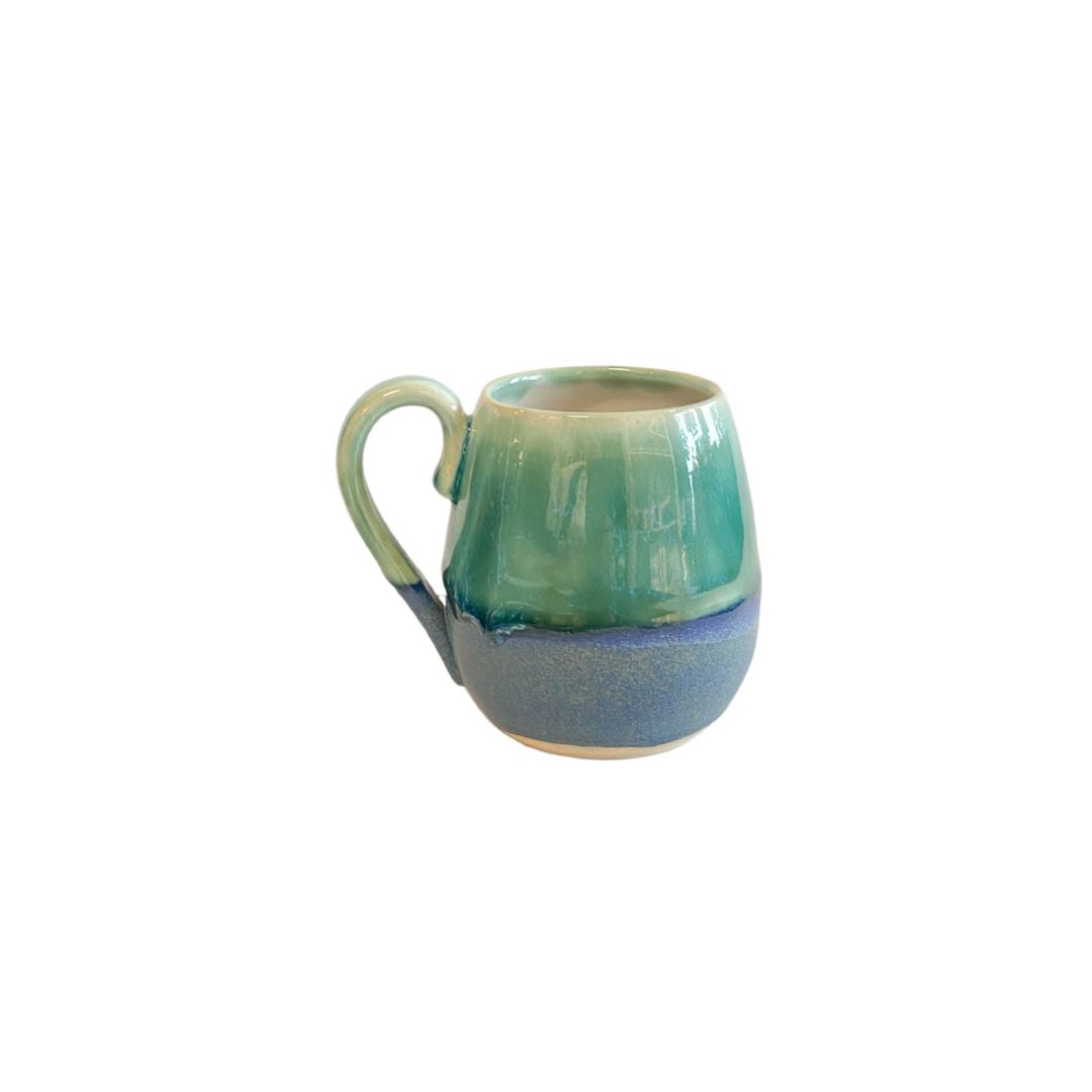 Pretty curved stoneware mug in blue and green glaze.