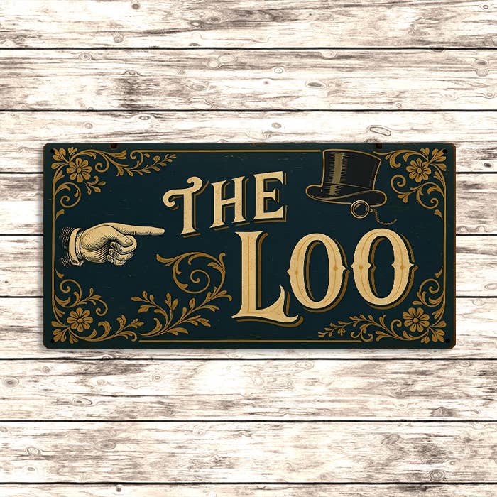Decorative sign with 'THE LOO' on a wooden background