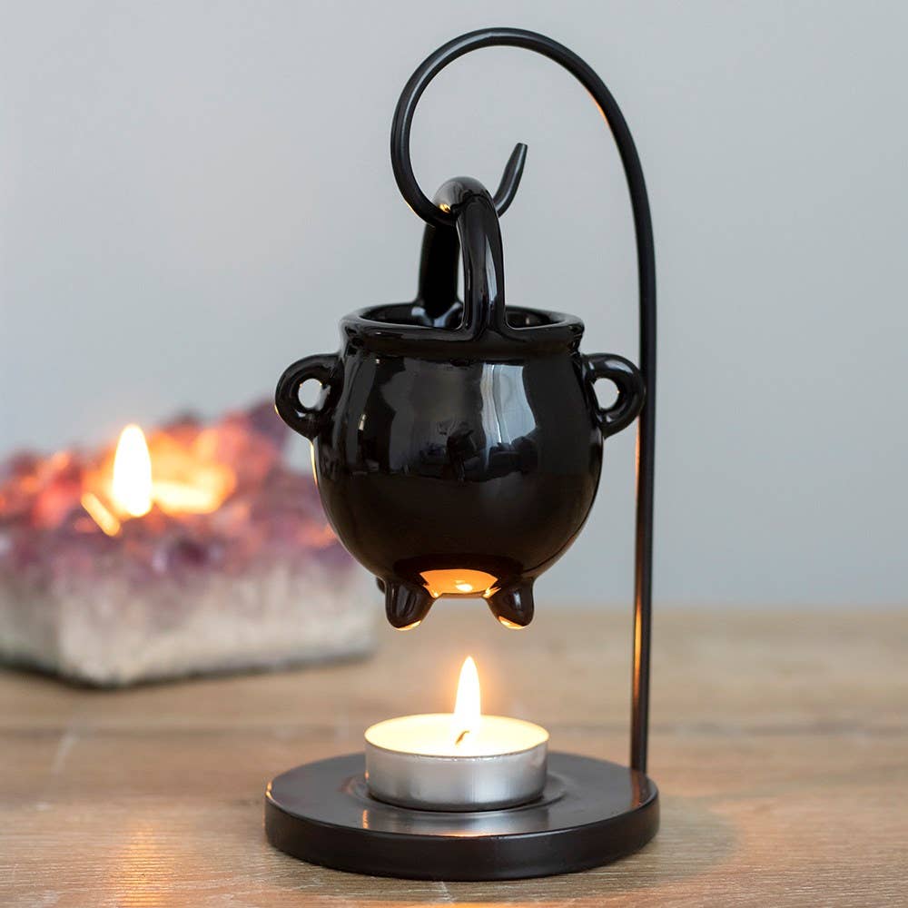 Black Ceramic Cauldron wax burner handing from a stand on a table