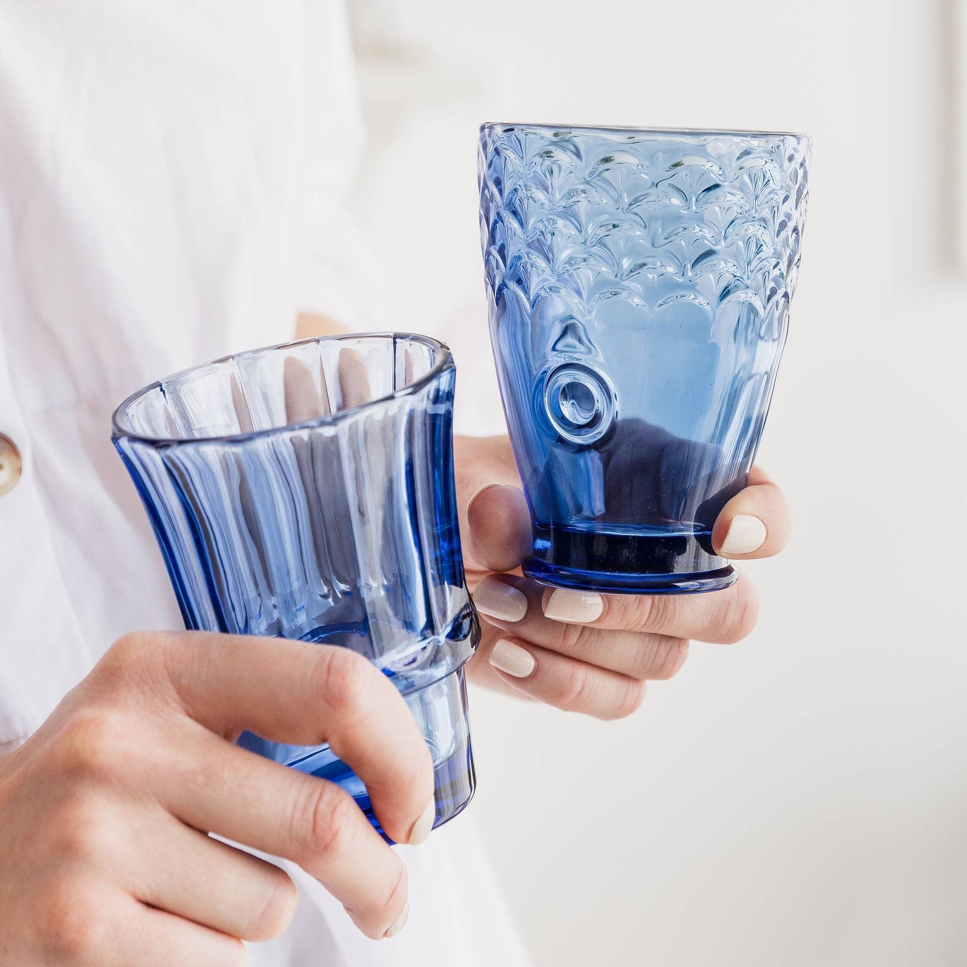 Person holding a blue glass in their hand 