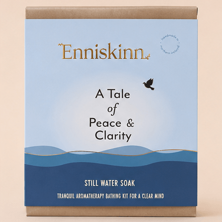 Enniskinn 'A Tale of Peace & Clarity' Still Water Soak packaging box, featuring a light blue and navy blue design with gold lettering and brown cardboard borders, set against a solid beige background.