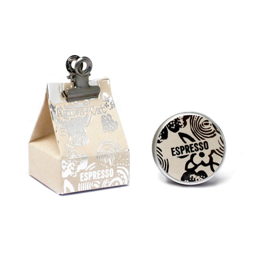 The image shows a round lip balm container with a black and white espresso martini design next to its unique packaging that reads 'Espresso Martini'.