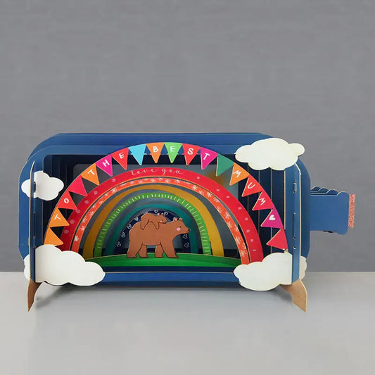 A colorful pop-up greeting card in a bottle with a rainbow, clouds, and a bear design, meant for mothers.