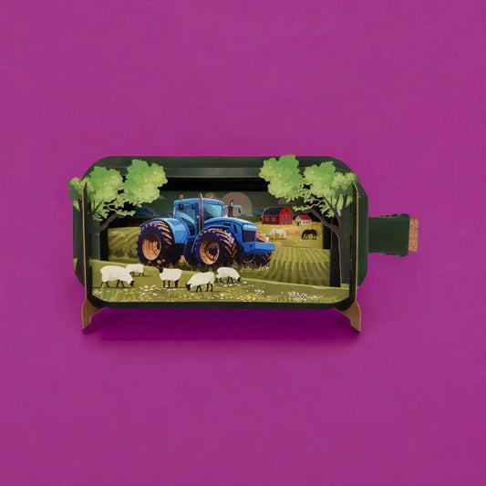 A pop-up greeting card depicting a three-dimensional scene with a blue tractor and sheep in a field, made by Alljoy Design.