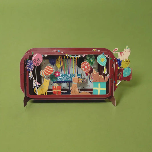 A colorful pop-up greeting card in a vertical orientation depicting a birthday or party scene with cats and cake.
