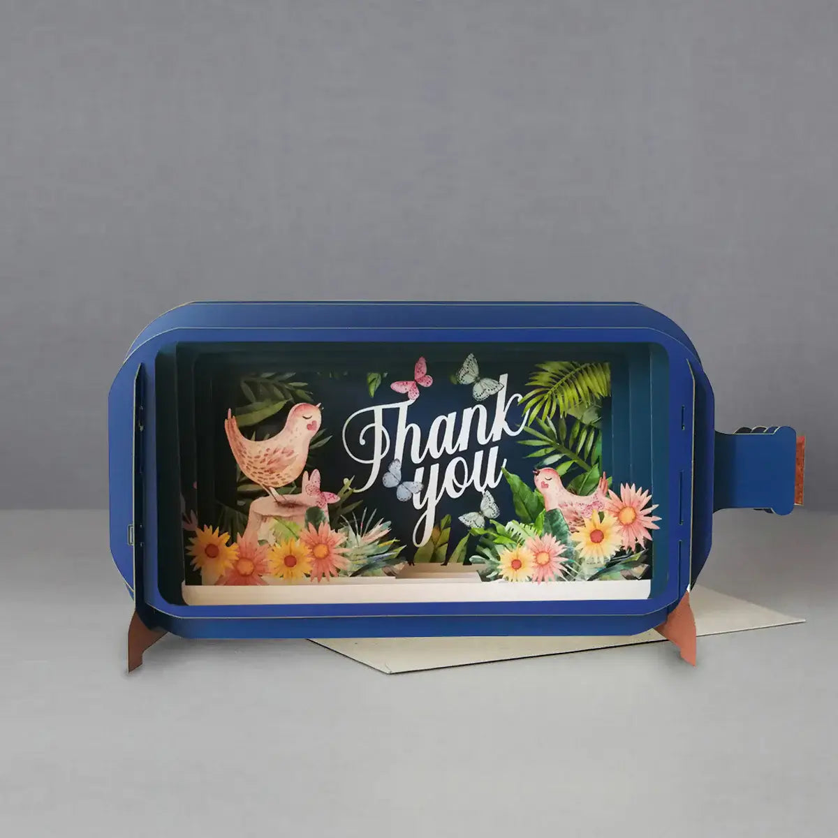A blue pop-up greeting card with a floral pattern and the words 'Thank you' displayed in the center.