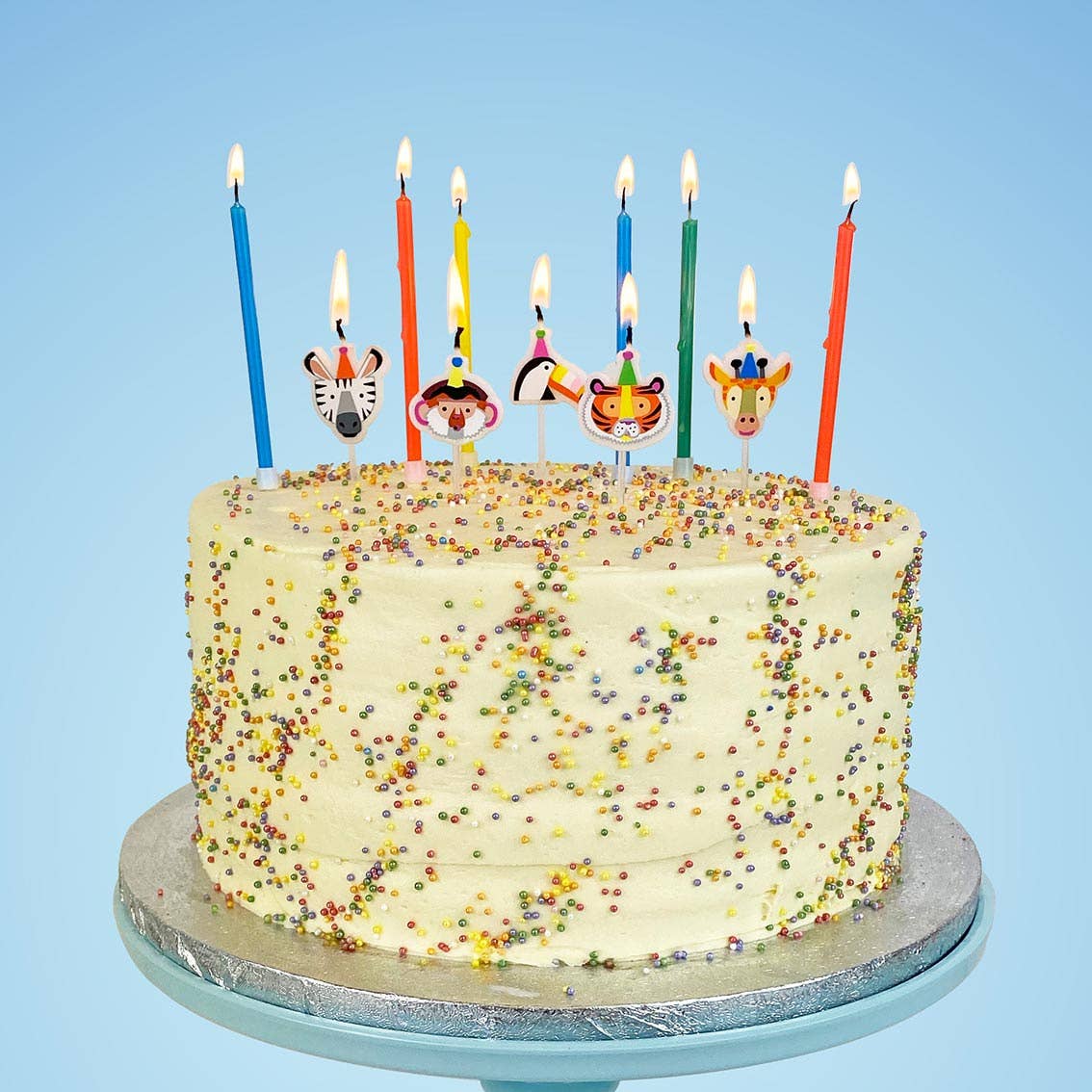 Birthday cake with colorful candles shaped like animal faces on a blue background