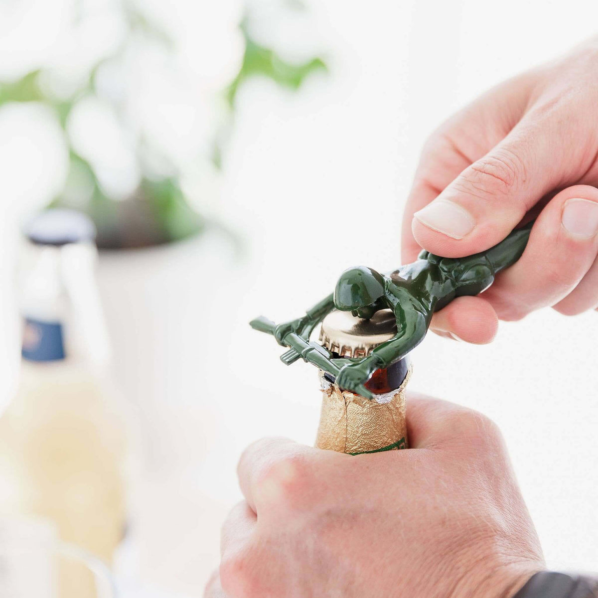 Person using a novelty bottle opener to remove a cork from a bottle.