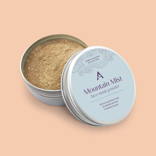 A round tin container with a blue label, open lid showing the beige face mask powder inside.