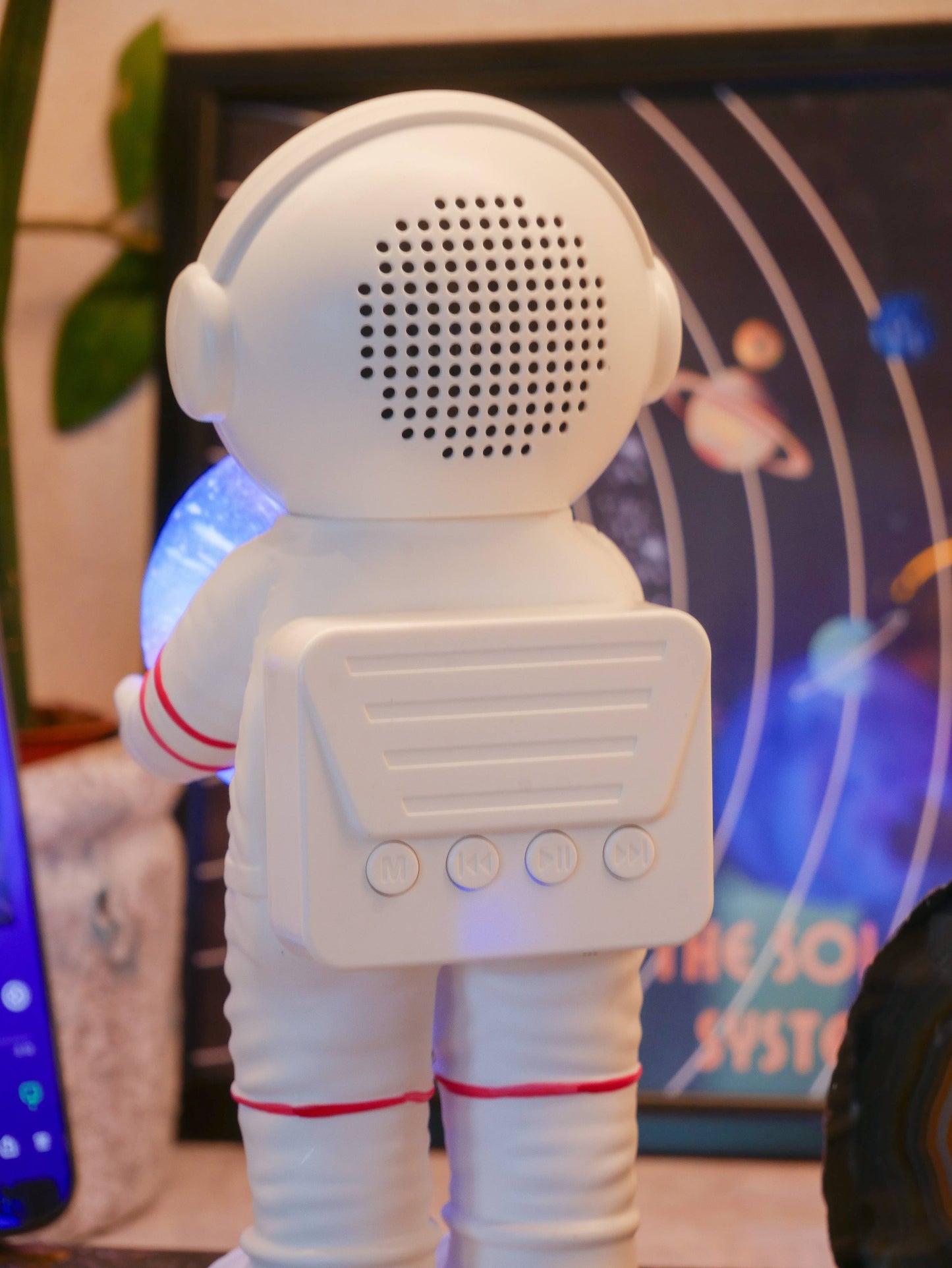 White astronaut-shaped speaker with a galaxy-themed background