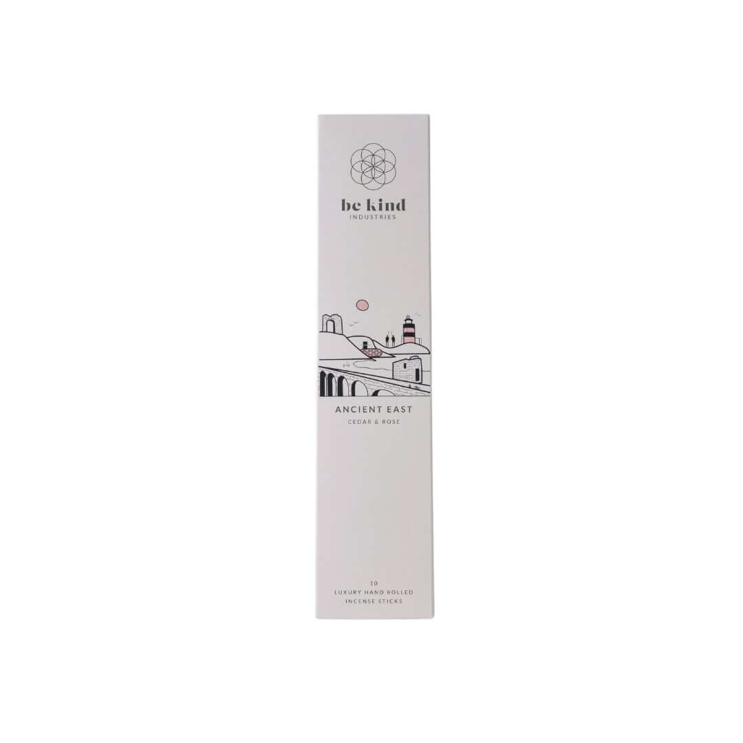 A package of Be Kind brand incense sticks, Ancient East-Cedar & Rose, with a graphic design representing the Irish landscape and coast