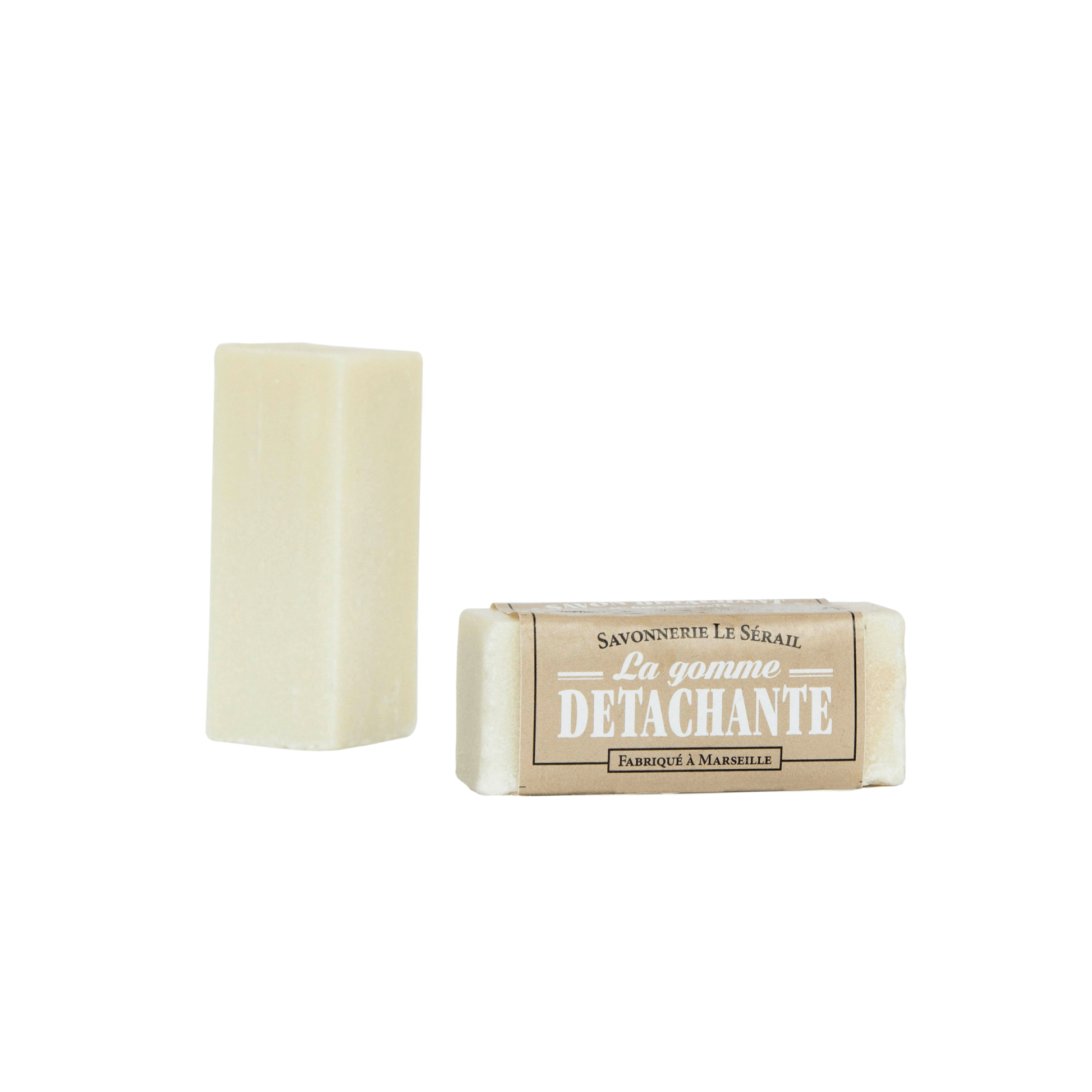 A bar of stain remover soap with a label indicating it is made with Marseille soap and baking soda, in a cylindrical container.