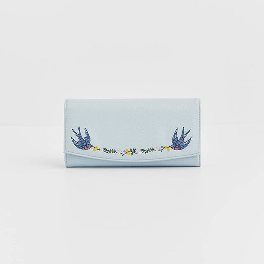 Light blue wallet with embroidered designs on a white background