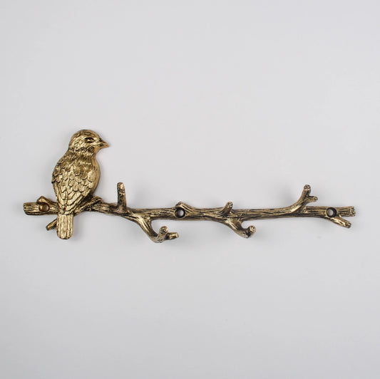 Bronze bird on a branch decorative item on a light gray background