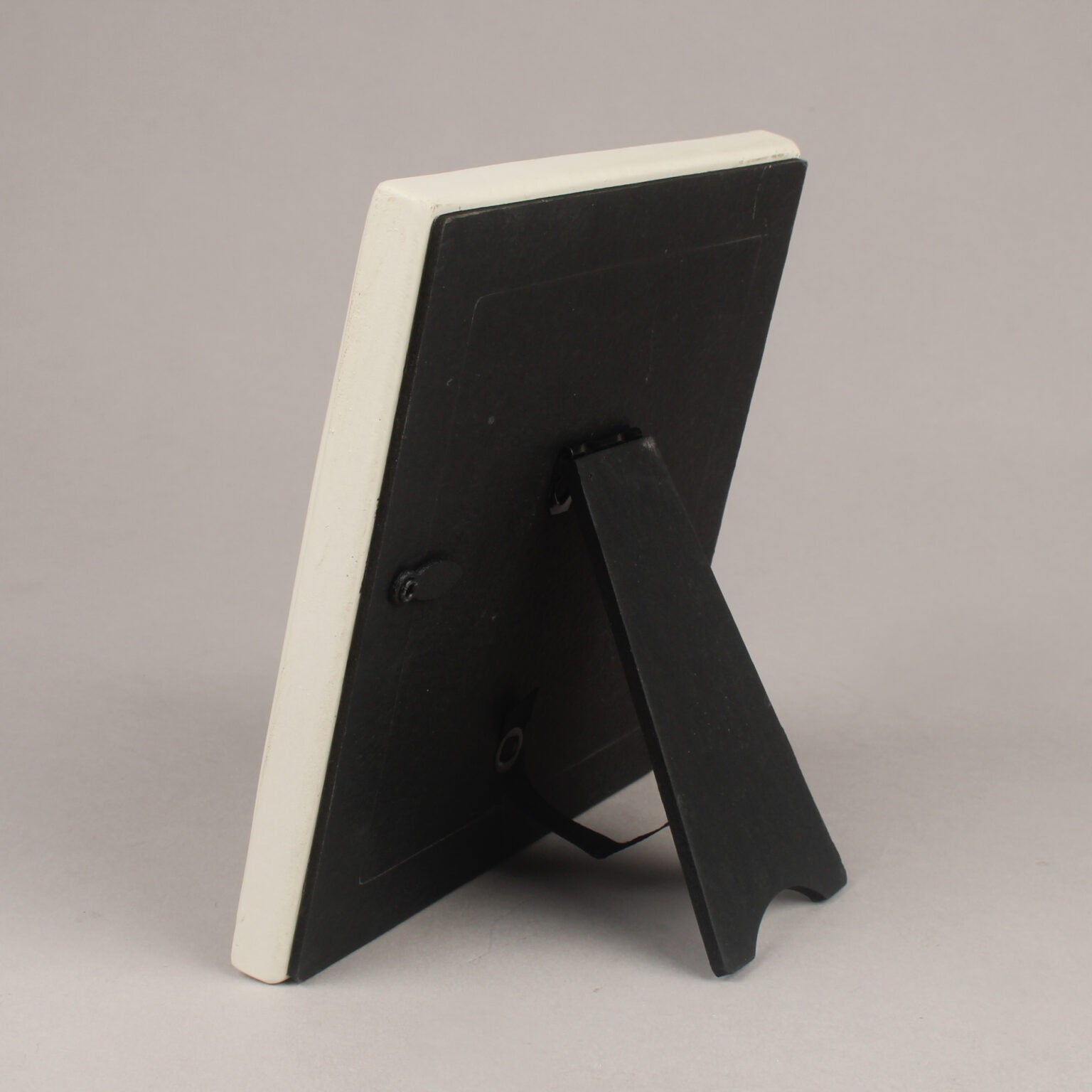 Black picture frame with a white back on a gray background
