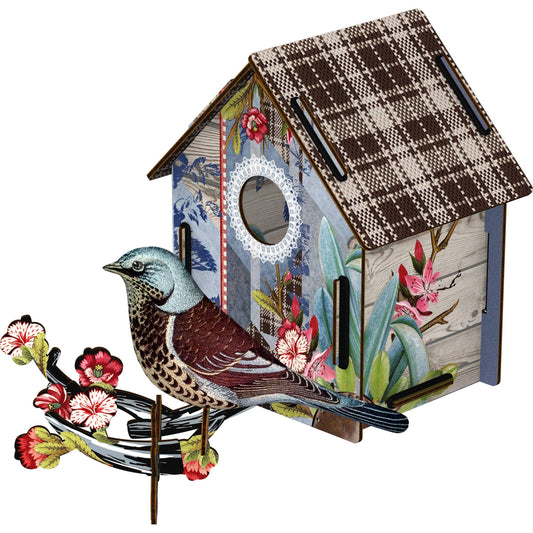 Decorative birdhouse with a bird on a branch against a white background