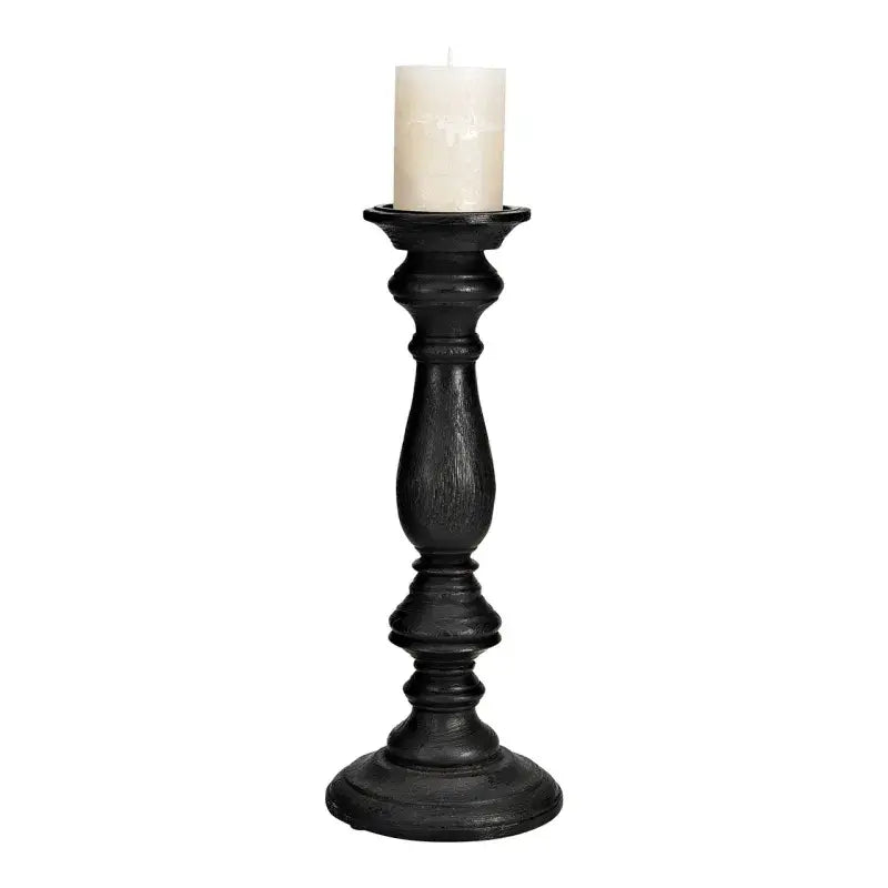 Black candle holder with a white candle on a white background