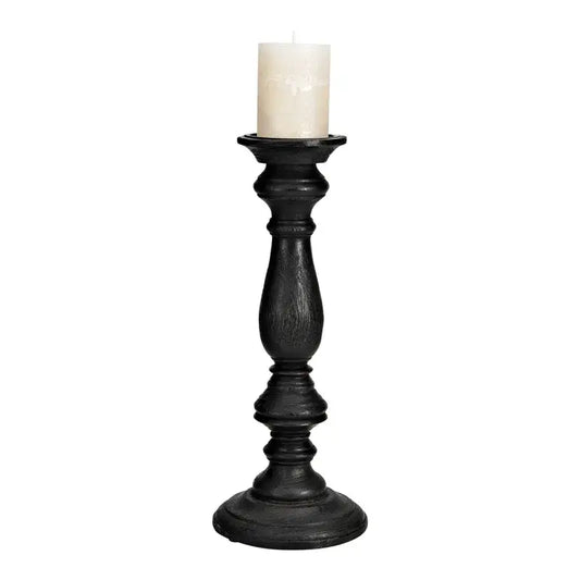 Black candle holder with a white candle on a white background