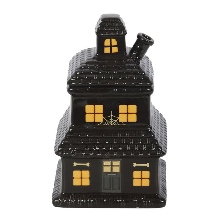 Black haunted house-shaped container with yellow windows on a white background