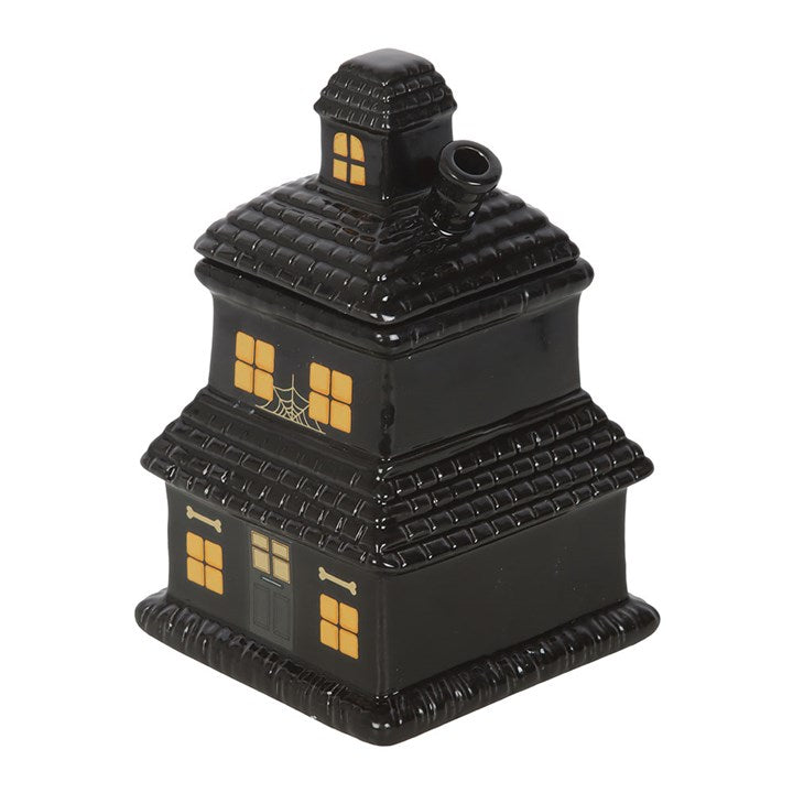 Black ceramic haunted house oil burner with spider webs and a bone on a white background