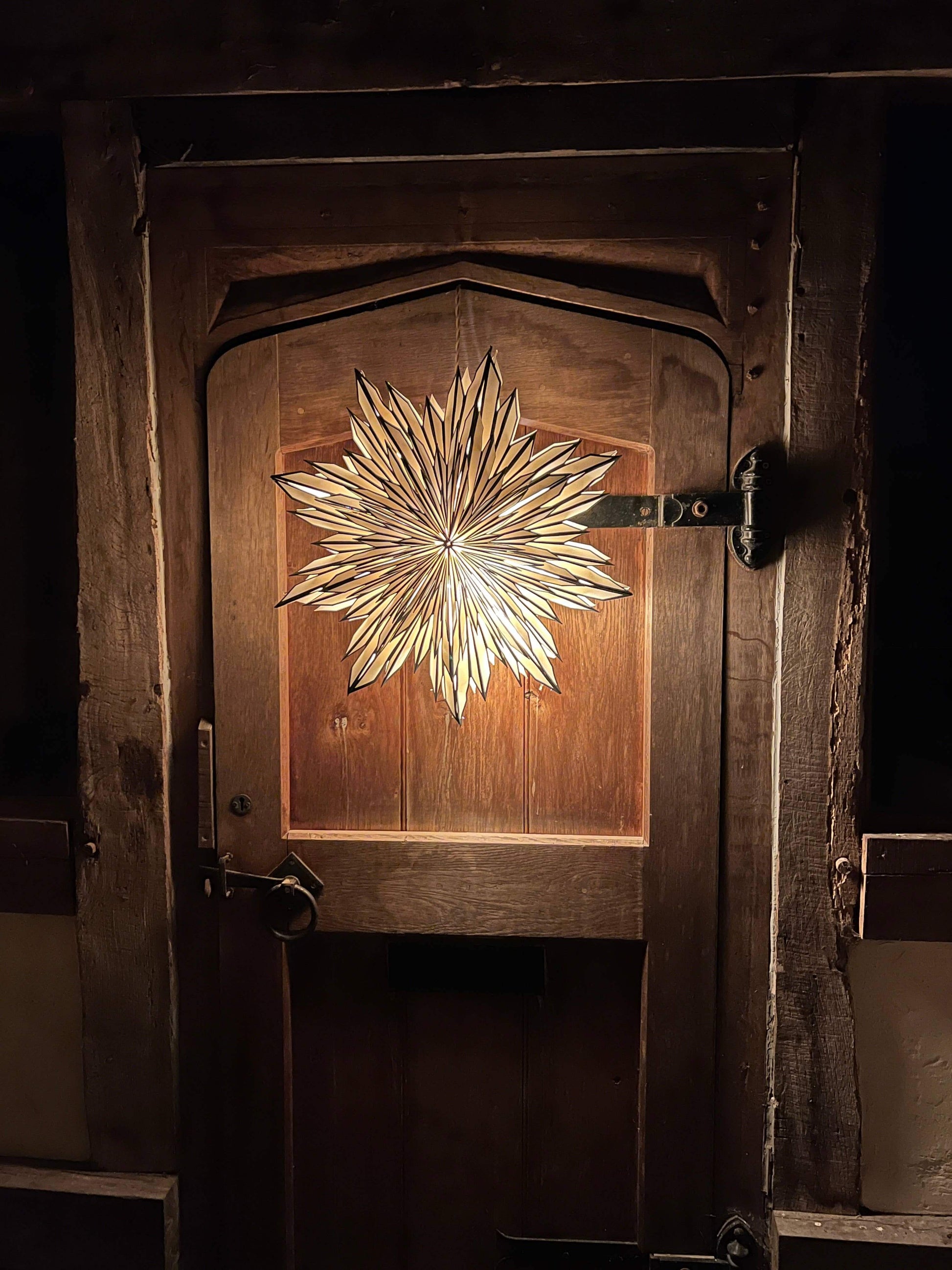 Black and white paper decoration lit up hanging on a wooden door