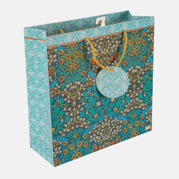 Floral patterned gift bag with a pom-pom tag on a white background