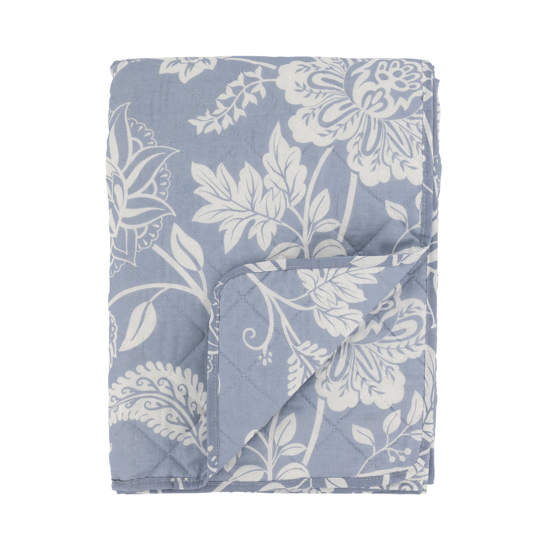 Floral patterned quilt with blue and white colors on a white background